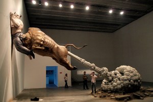 In this photo taken Sunday, Sept. 27, 2009, a sculpture by Chinese artist Chen Wenling entitled "What You See Might Not Be Real" is on display at a gallery in Beijing, China. The artwork is a critique of the global financial crisis with the bull representing the golden bull of wall street and the man pinned to the wall representing the jailed financier Bernard Madoff. (AP Photo/Ng Han Guan)